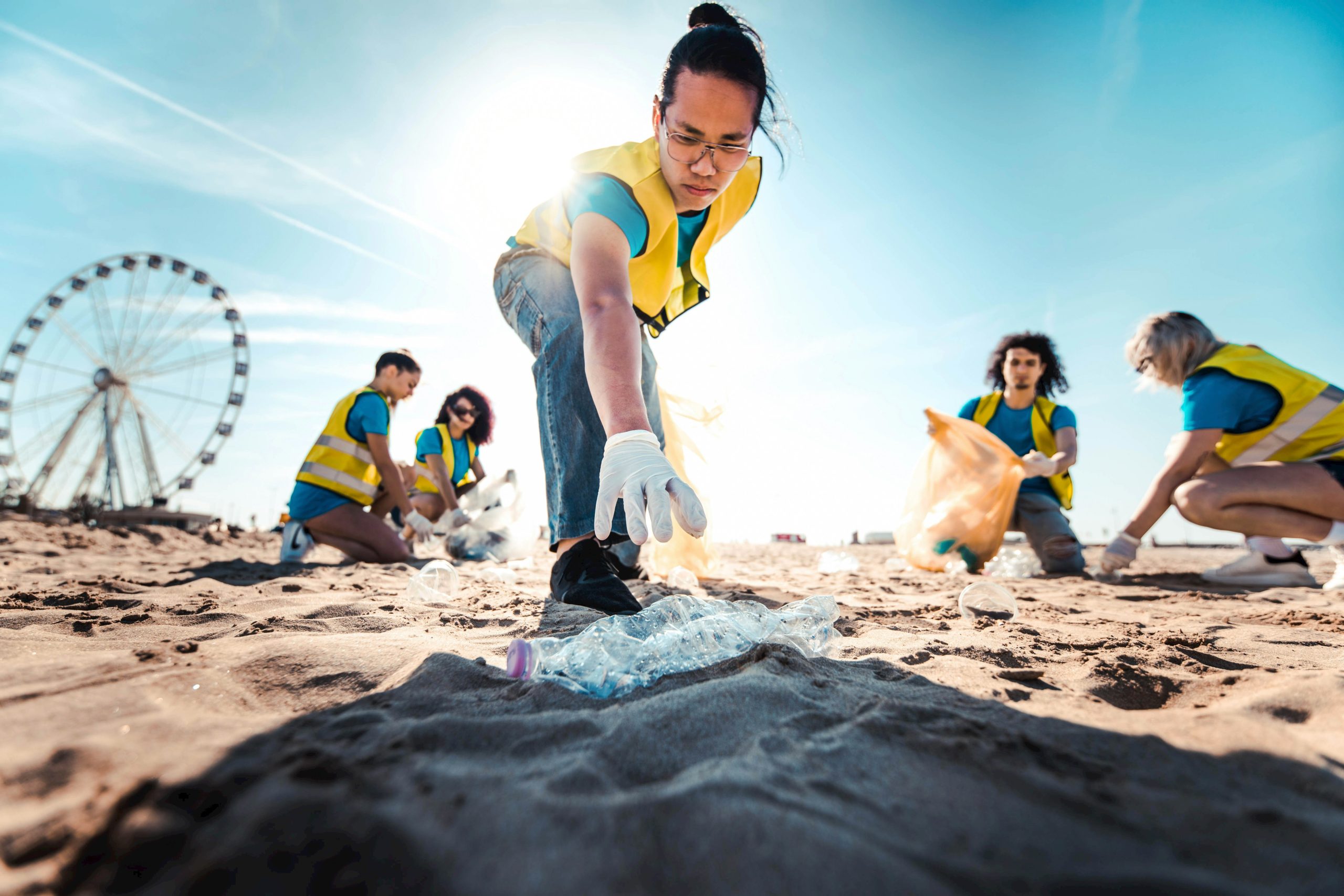 Volunteer cleaning up plastic bottle on the beach.