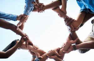 Looking up at conjoined hands forming a circle.