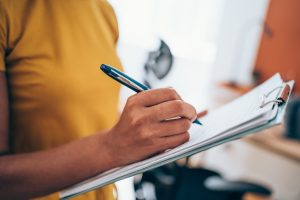 Cropped shot of an unrecognizable businesswoman making notes on a clipboard inside of the office.