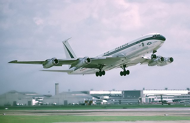 A photograph of a jet engine airplane lifting off from the runway.