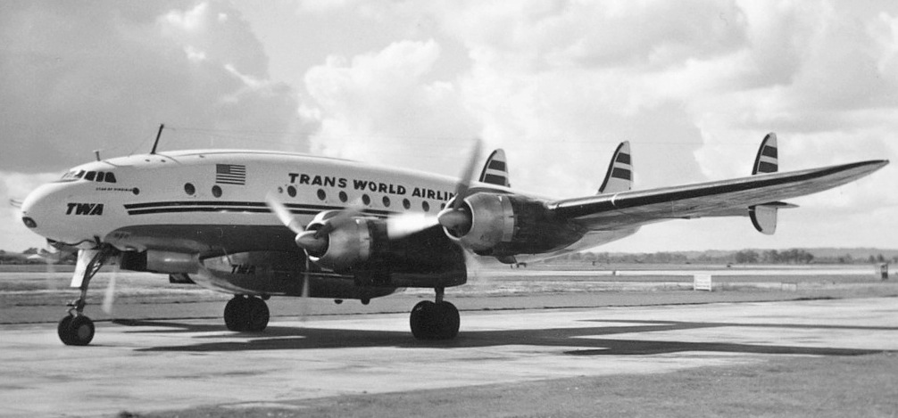A black and white photograph of a TWA airplane on the tarmac.