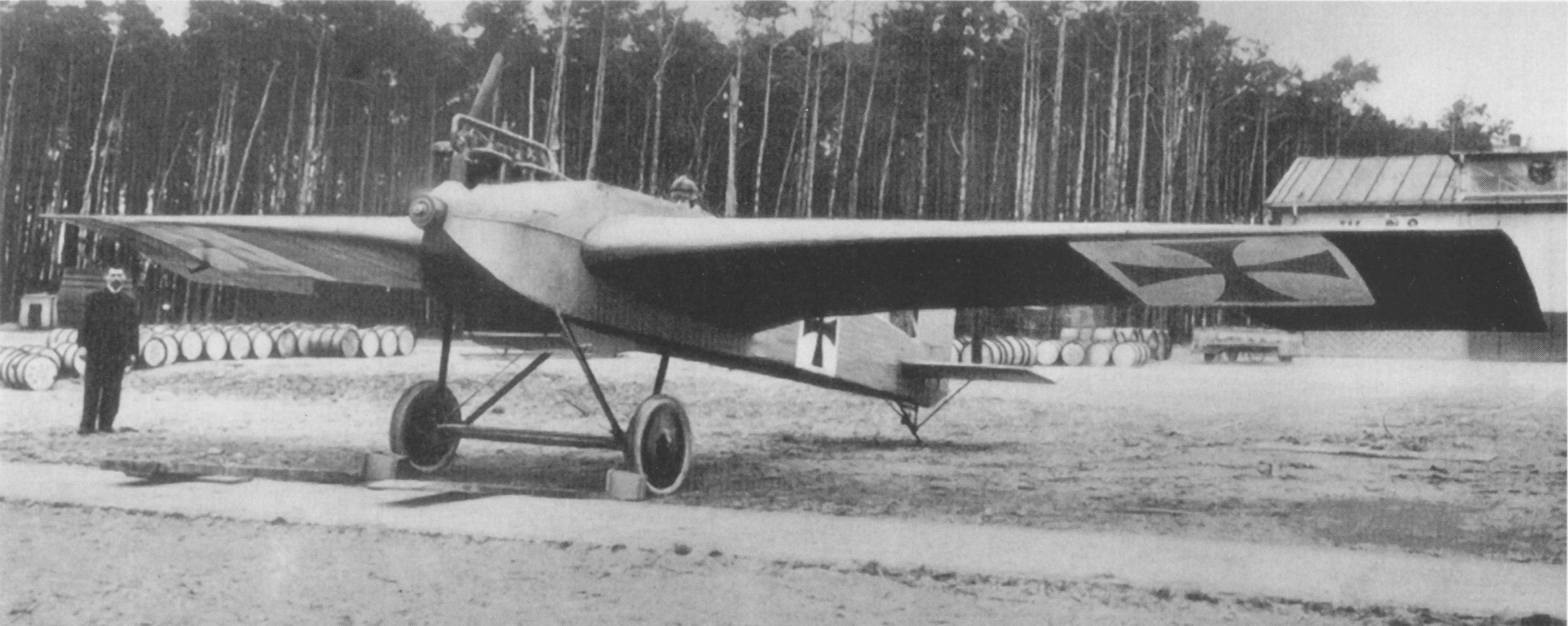 A black and white photograph of an monoplane with cross emblems on the wings and fuselage.
