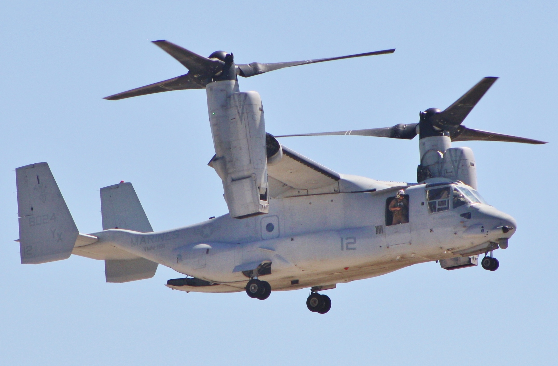A large light gray helicopter with multiple visible rotor blades.